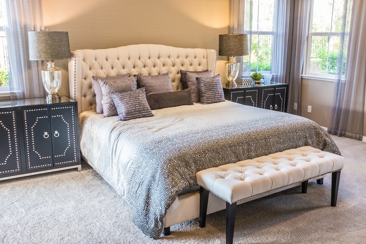 Guest room corner with neatly arranged bedding and natural light